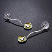 Close up of KHAISTA shiny arc long dangle drop earrings
