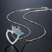 Side angle view of KHAISTA silver heart crown CZ pendant necklace