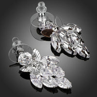 Close up of KHAISTA sitting butterfly crystal drop earrings