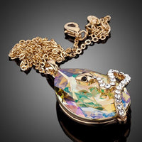 Side angle view of KHAISTA sleeping snake crystal pendant necklace