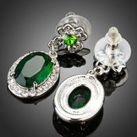 Close up of KHAISTA space green oval CZ drop earrings