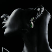 Side angle view of KHAISTA space green oval CZ drop earrings