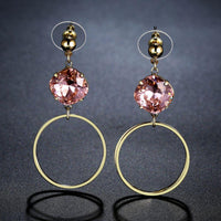 Close up of KHAISTA pink Austrian crystal square circle drop earrings