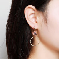 Side angle view of KHAISTA pink Austrian crystal square circle drop earrings
