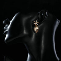 Side angle view of KHAISTA starfish rhinestone drop earrings