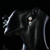 Side angle view of KHAISTA sunflower crystal drop earrings