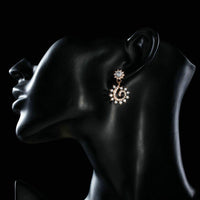 Side angle view of KHAISTA sunflower design crystal drop earrings