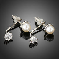 Close up of KHAISTA synthetic pearl stud earrings