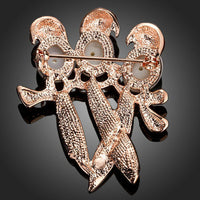Close-up of red crystals on Khaista birds brooch