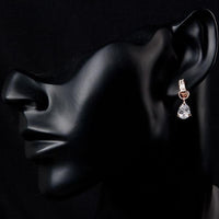 Side angle view of KHAISTA transparent CZ raindrop earrings