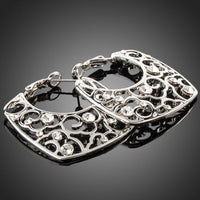 Side angle view of KHAISTA transparent Stellux Austrian hoop earrings