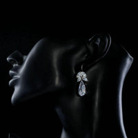 Side angle view of KHAISTA tree design CZ drop earrings