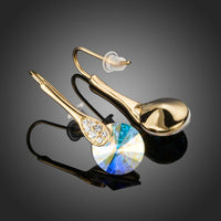 Close up of KHAISTA gold plated round crystal drop earrings