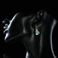 Side angle view of KHAISTA gold plated round crystal drop earrings