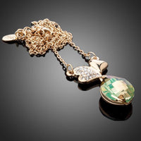 Side angle view of KHAISTA two leaf clover crystal pendant necklace