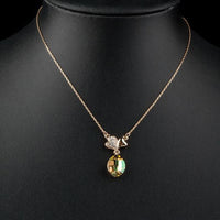 Close up detail of KHAISTA two leaf clover crystal pendant necklace