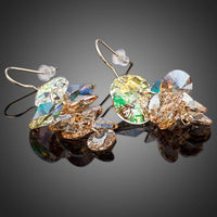 Side angle view of KHAISTA unique Stellux crystal drop earrings
