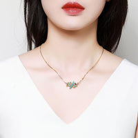 Side angle view of KHAISTA vintage letter X pendant necklace