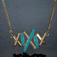 Close up detail of KHAISTA vintage letter X pendant necklace