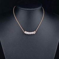 Side angle view of KHAISTA connected waterdrop crystal pendant necklace