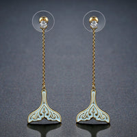 Close up of KHAISTA crystal whale fluke drop earrings