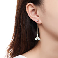 Side angle view of KHAISTA crystal whale fluke drop earrings