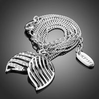 Close up detail of KHAISTA white gold angel wings Stellux crystal necklace
