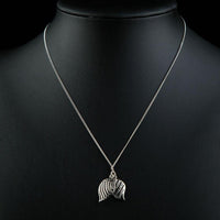 Side angle view of KHAISTA white gold angel wings Stellux crystal necklace