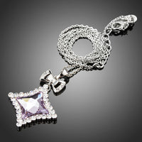 Side angle view of KHAISTA white gold bow knot long chain necklace