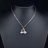 Close up detail of KHAISTA white gold crystal goose necklace