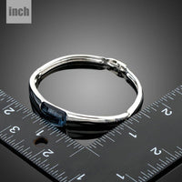 Side angle view of KHAISTA white gold geometric crystal bangle