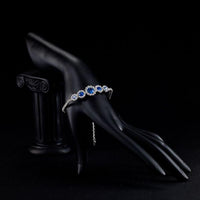 Side angle view of KHAISTA white gold navy blue crystal bracelet
