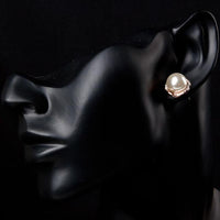Side angle view of KHAISTA white pearl dome stud earrings