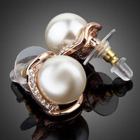 Close up of KHAISTA white pearl dome stud earrings