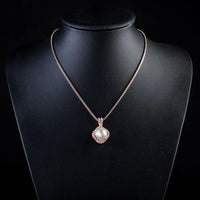Side angle view of KHAISTA white pearl pendant necklace