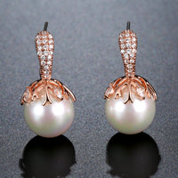 Close up of KHAISTA white pearl stud earrings