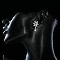 Side angle view of KHAISTA white rose CZ waterdrop earrings