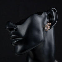 Side angle view of KHAISTA X charm crystal stud earrings